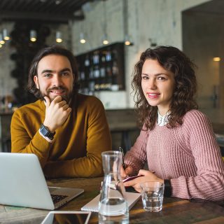 Man and woman working together on a laptop at a co-working space